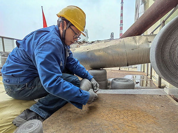 5月10日中午，在動力車間三期工藝除氧器平臺上，黨員突擊隊隊員劉瑞斌正在纏繞新填料.jpg