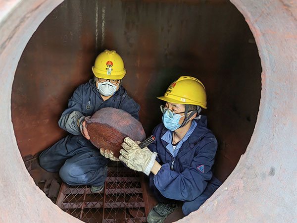 5月11日，動(dòng)力車間三期工藝除氧器內(nèi)部，黨員突擊隊(duì)隊(duì)員劉瑞斌和李震正在清理舊填料.jpg